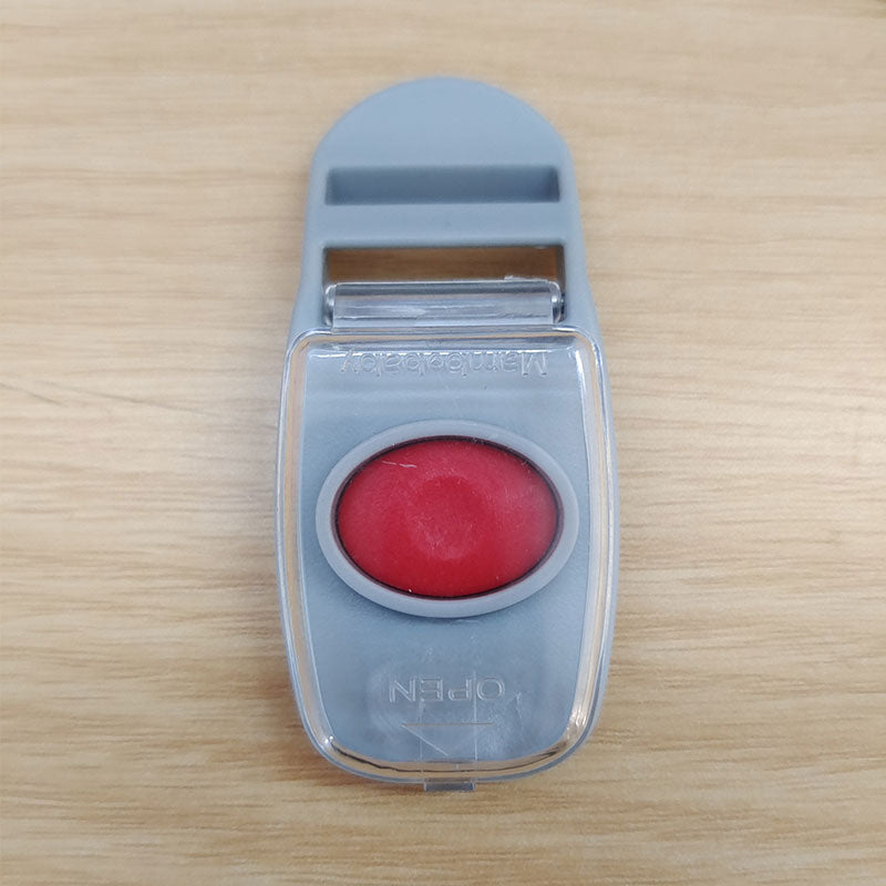 Close-up of the Mambobaby™ Float child-proof safety lock and unlock button for the professional 5-point harness system.