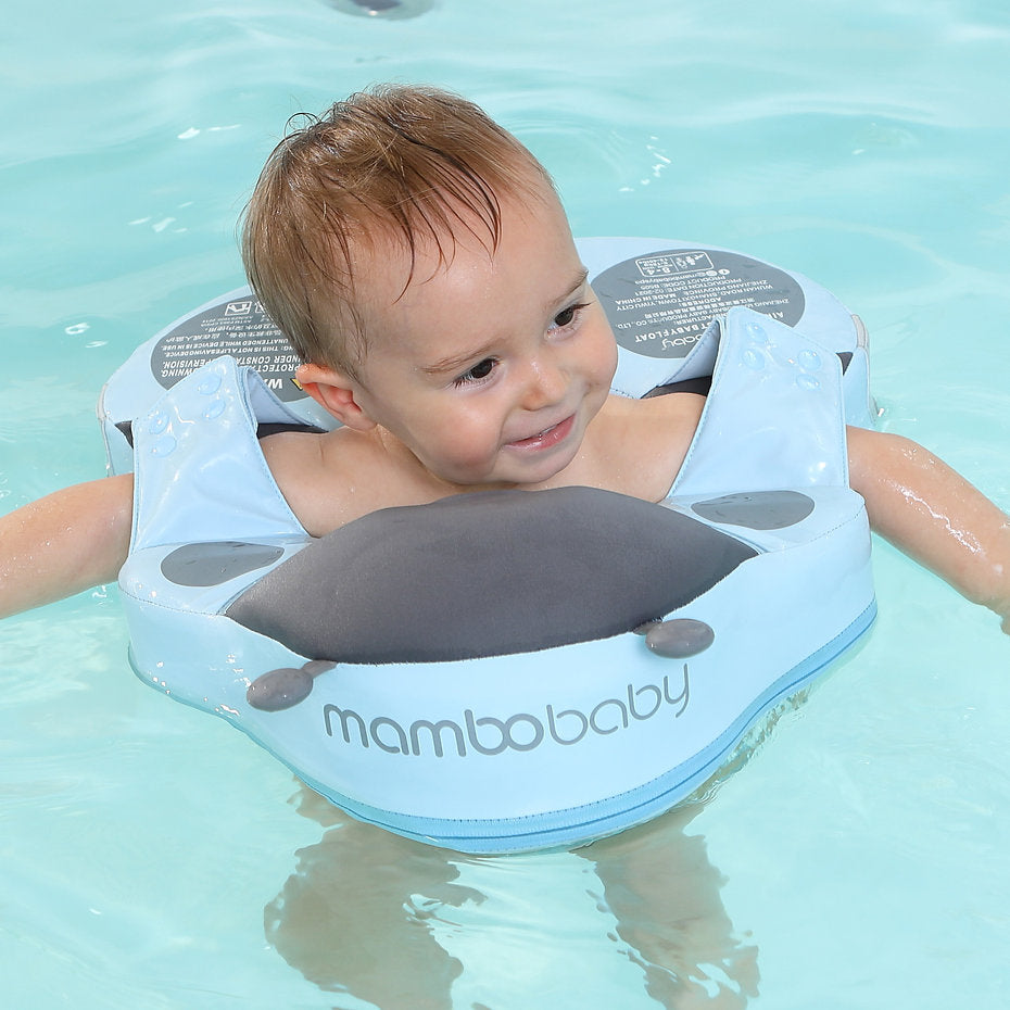 A toddler enjoying a holiday swim in the Mambobaby™ Ladybug Shoulder Float, promoting water confidence and leg movement.